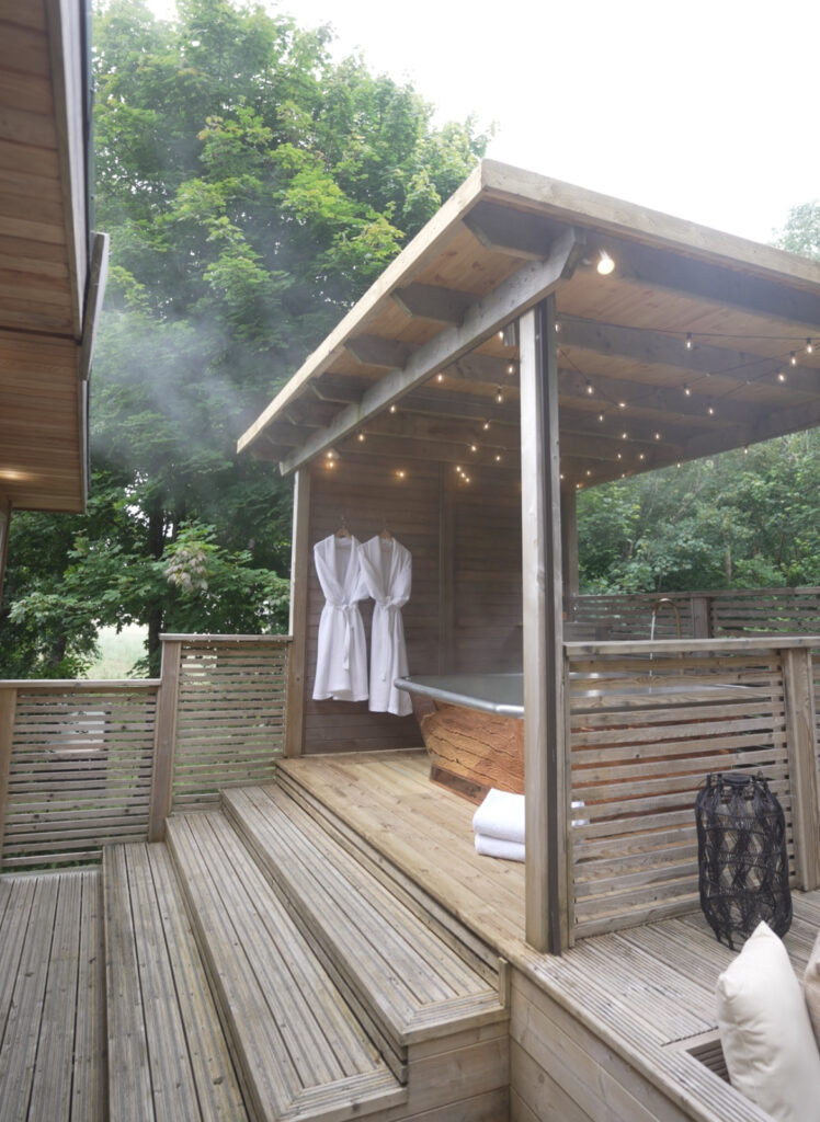 The image features a William Holland Outdoor Copper bath at Charter Oak Luxury Lodges.